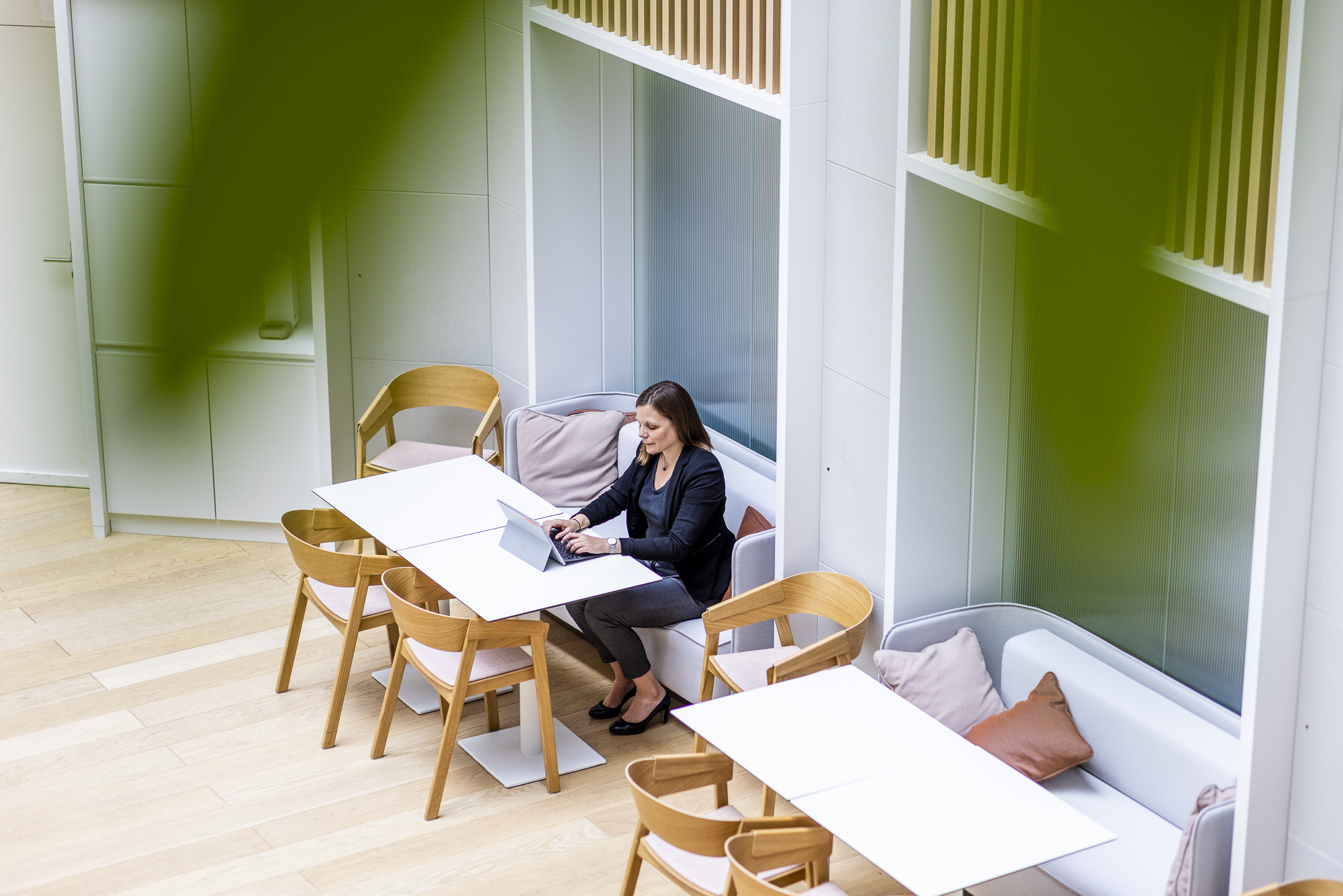 Woman sitting at the Lazard cafeteria working on her computer